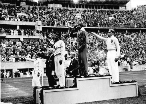 Jesse Owens en un podium de los JJOO de Berlín